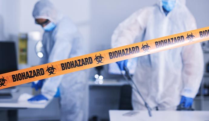 Professionals performing biohazard cleanup in a sealed and restricted area