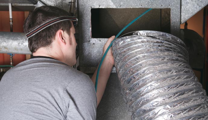Professional worker cleaning a air duct