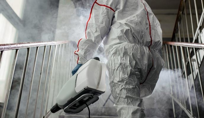 Professional worker disinfecting staircase