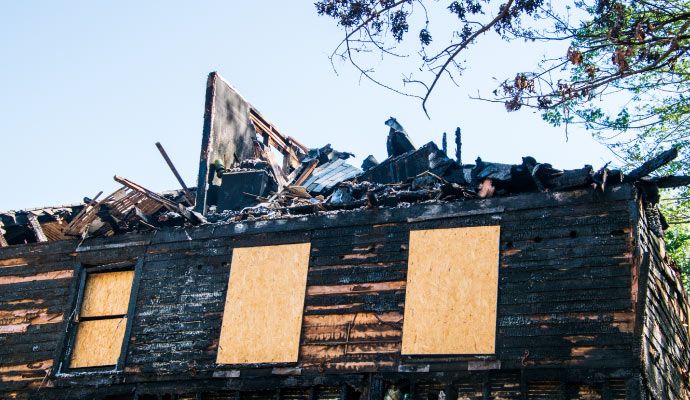 House affected by fire with windows covered with boards