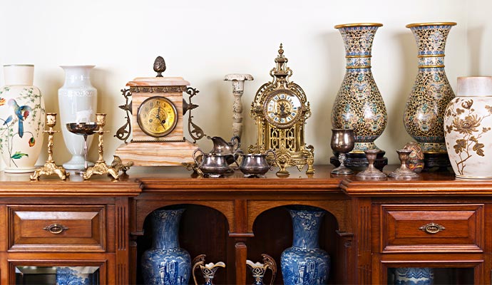 Collection of clean and polished antique items displayed neatly on a wooden cabinet
