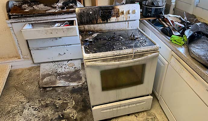 Fire-damaged washing machine showing visible burn marks and surface discoloration