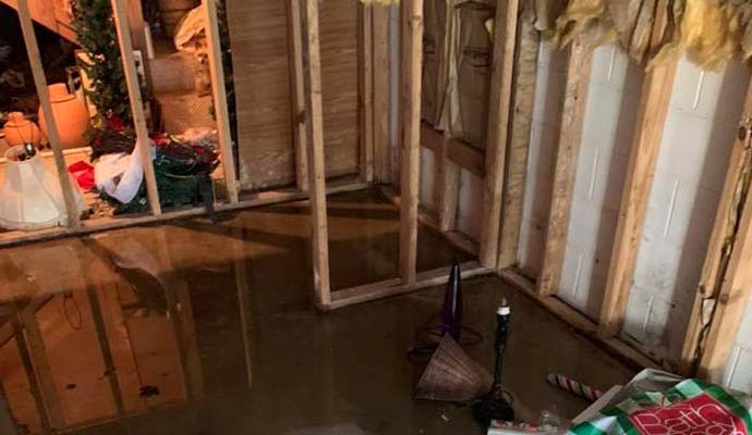 Flooded basement with exposed wooden framing and standing water
