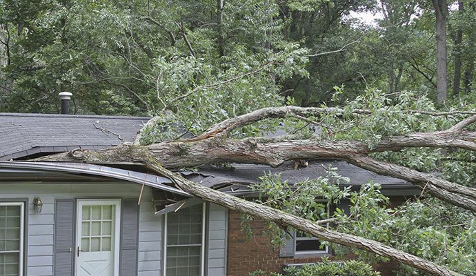 Residential home showing structural and roof damage caused by a hurricane