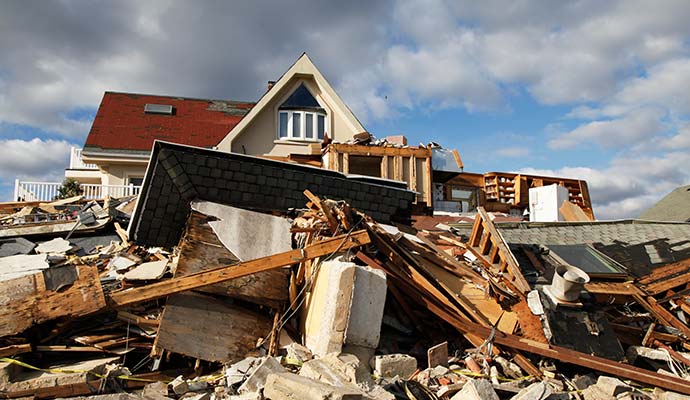 Residential home showing structural and roof damage caused by a hurricane