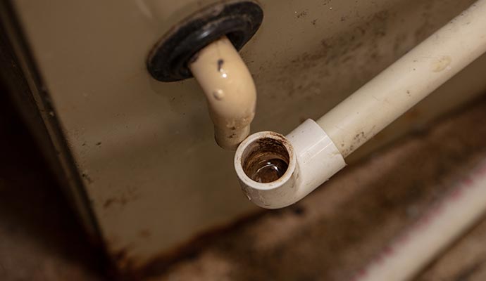 Close-up view of an AC unit drain pipe used for condensation drainage.