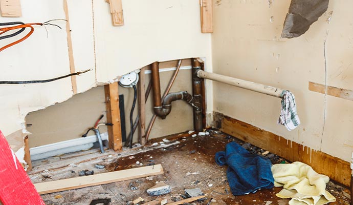 Damaged wall exposing leaked water pipe