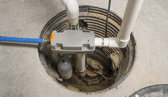 Close-up view of a newly installed sump pump with connected drainage pipes.